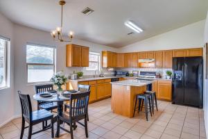 a kitchen with a table and chairs and a black refrigerator at Thatcher Home with Fenced Backyard 3 Mi to Downtown in Thatcher