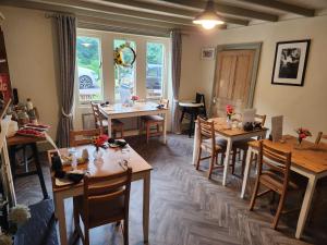 a restaurant with wooden tables and chairs and a window at Mulgrave Country Cottage in Whitby