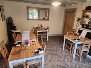 een kamer met houten tafels en stoelen en een open haard bij Mulgrave Country Cottage in Whitby