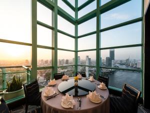 een tafel in een kamer met een groot raam bij Chatrium Hotel Riverside Bangkok in Bangkok