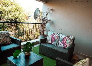 a balcony with two chairs and a coffee table at S&D Luxury Apartment in Roodepoort