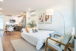 a bedroom with a large white bed and a living room at Howell Haven 19 BY Betterstay in Seattle