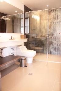 a bathroom with a toilet and a glass shower at San Juan Hotel Boutique Pasto in Pasto