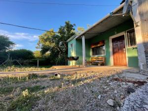 a green building with a bench in front of it at Apto en Minas con amplio fondo, aire acondicionado, ideal para descansar in Minas +7 photos