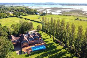 uma vista aérea de uma casa com piscina e árvores em The Shallows by inspirestays-com em North Hayling