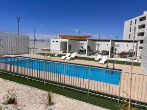 une clôture autour d'une piscine dans un bâtiment dans l'établissement Dpto 3D 2B + Quincho propio By Terrabahia, à Bahia Inglesa