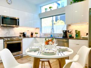 Capitol Luxe Two BY Betterstay في سياتل: مطبخ بطاولة بيضاء وكراسي بيضاء