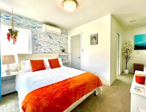 a bedroom with a large bed with an orange blanket at Capitol Luxe Two BY Betterstay in Seattle