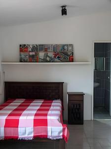 een slaapkamer met een rood en wit gestreept bed bij Sítio com Piscina em Aldeia in Camaragibe