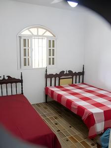 two beds in a room with a red and white checkered floor at Sítio com Piscina em Aldeia in Camaragibe