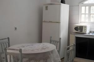 eine Küche mit einem Tisch und einem weißen Kühlschrank in der Unterkunft Sítio com Piscina em Aldeia in Camaragibe