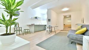 a living room with a blue couch and a plant at Vilnius town square apartments SELF CHECK-IN 24h by H&H in Vilnius