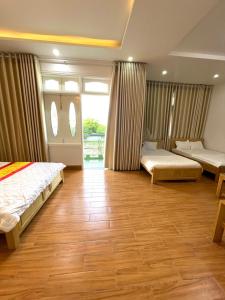 1 Schlafzimmer mit 2 Betten und Holzboden in der Unterkunft Vũng Tàu Sunhotel in Vũng Tàu