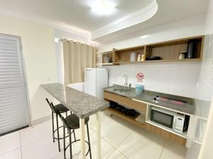 a kitchen with a counter and a sink and a refrigerator at L'acqua DiRoma 1 2 3 4 5 L in Caldas Novas