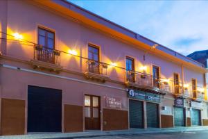 a pink building with windows and balconies on a street at Siete Balcones Hotel y Coworking in Pasto