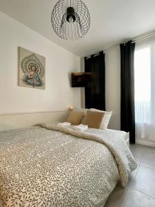 een slaapkamer met een groot bed en een kroonluchter bij Studio Cosy Vanves Paris Porte de Versailles in Vanves