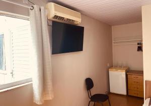 a room with a fan and a window and a chair at Hotel Prudente RP in Ribeirão Preto