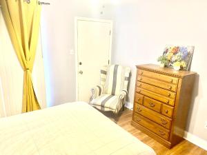 a bedroom with a bed and a chair and a dresser at Cozy place near FedEx Forum- free shuttle to downtown in Memphis