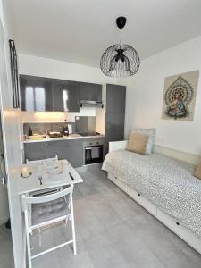 een slaapkamer met een bed en een tafel en een keuken bij Studio Cosy Vanves Paris Porte de Versailles in Vanves