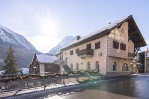 a building in a town with mountains in the background at Chasina Bagnera in Scuol