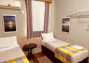 a hotel room with two beds and a window at Hotel Prudente RP in Ribeirão Preto +18 photos