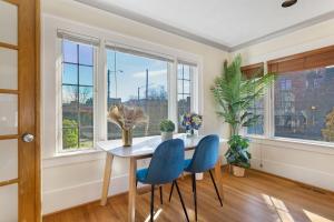 a dining room with a table and chairs and windows at Vintage Seattle Gem BY Betterstay in Seattle