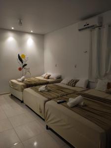 Cette chambre comprend 3 lits. dans l'établissement Pousada Marajó For You - Suíte Master, à Soure