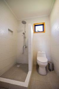 La salle de bains est pourvue de toilettes, d'une douche et d'une fenêtre. dans l'établissement Moderna Cabaña en Villarrica, à Villarrica