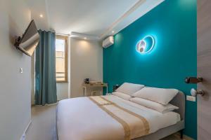 a bedroom with a blue wall and a bed with pillows at Hyper Lodge Termini GuestHouse in Rome