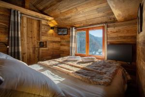 1 dormitorio con cama y ventana grande en Le Mazot de La Caillère - OVO Network en La Giettaz