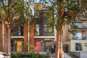 an apartment building with red doors and trees at Belmont Boutique 4 BY Betterstay in Seattle
