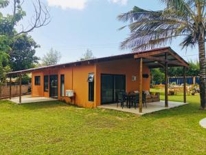 ein kleines gelbes Haus mit einer Veranda in der Unterkunft Twin House #2 in Ponta do Ouro