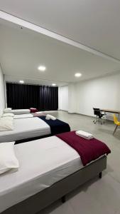 a bedroom with three beds and a piano at Flat Central in Bonito