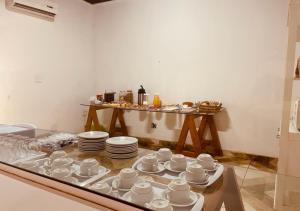 kopjes en borden op een glazen tafel bij Hotel Prudente RP in Ribeirão Preto