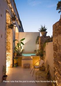 eine Terrasse mit 2 Stühlen und einem Pool in der Unterkunft Special apartment in Noto in Noto