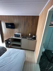 a hotel room with a bed and a sink at Loft Lux 5 in Chapecó