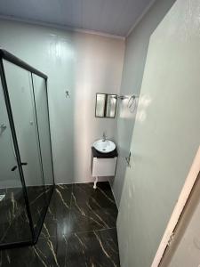 W łazience znajduje się umywalka i lustro. w obiekcie Loft Lux 5 w mieście Chapecó