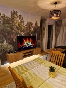 ein Wohnzimmer mit einem TV und einem Tisch mit einem sidx sidx in der Unterkunft My River Walk apartment - Ilidza in Sarajevo