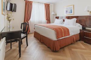 a hotel room with a large bed and a desk at Orly Suites in Santiago