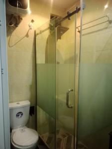a bathroom with a toilet and a glass shower at Berkley House in Lagos