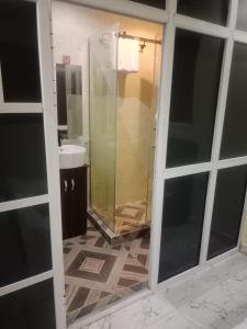 a bathroom with a glass shower and a sink at Berkley House in Lagos