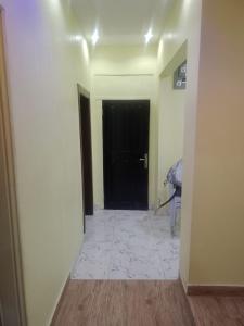 a hallway with a black door and a tile floor at Berkley House in Lagos