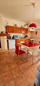 a kitchen with a table and red chairs in a room at Casa da Ti Bia in Setúbal