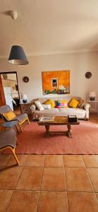 ein Wohnzimmer mit einem Sofa und einem Tisch in der Unterkunft Casa da Ti Bia in Setúbal