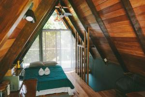 - une chambre avec un lit doté d'une couette verte et d'une fenêtre dans l'établissement Toku, à Fortuna