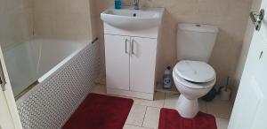 a bathroom with a toilet and a sink and a bath tub at Simply Relax, Eastham London in London