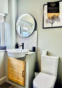 y baño con lavabo, aseo y espejo. en The Rose Garden - House in the Heart of Basildon by Artisan Stays I Free Parking I Perfect for Contractors or Families, en Basildon