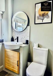y baño con lavabo, aseo y espejo. en The Rose Garden - House in the Heart of Basildon by Artisan Stays I Free Parking I Perfect for Contractors or Families, en Basildon