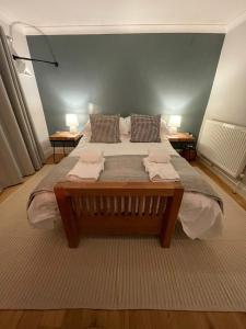 a large bed in a room with two tables at Cottage 7 mins from Henley with gated parking in Henley on Thames