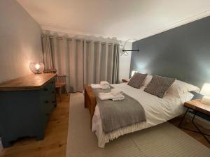 a bedroom with a bed and a dresser and a desk at Cottage 7 mins from Henley with gated parking in Henley on Thames